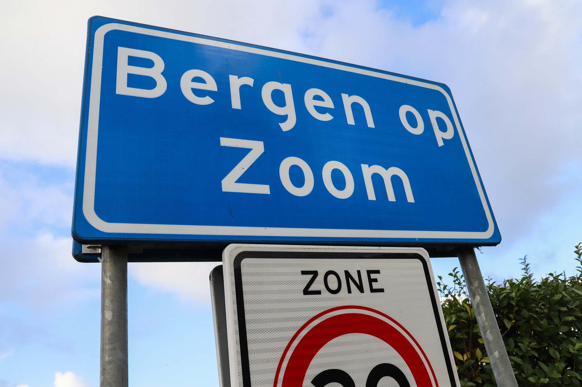 huizen nieuwe koopwoningen stadsnaambord bord verkeersbord bebouwde kom met letters bergen op zoom ingang entree stad