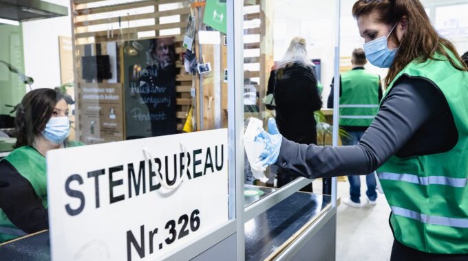 Een model-stembureau in Rotterdam Charlois wordt gedesinfecteerd. Voor de Tweede Kamerverkiezingen moeten alle stembureaus coronaproof worden ingericht. ANP SEM VAN DER WAL