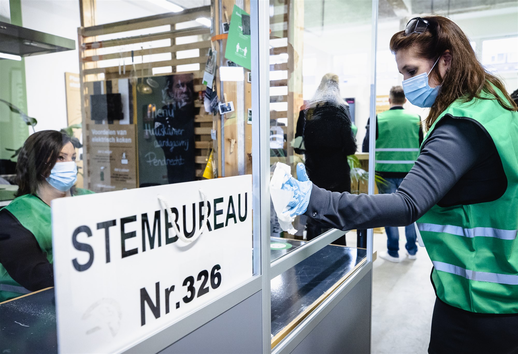 Een model-stembureau in Rotterdam Charlois wordt gedesinfecteerd. Voor de Tweede Kamerverkiezingen moeten alle stembureaus coronaproof worden ingericht. ANP SEM VAN DER WAL
