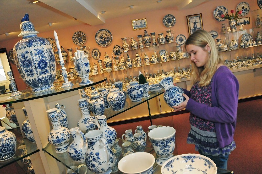 Bezoeker bekijkt Delfts Blauw in de Delftse Pauw