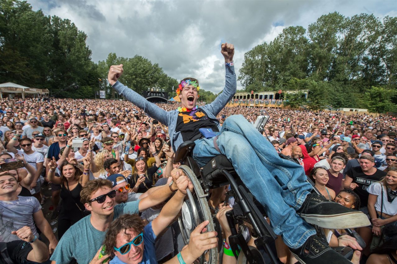 2016-08-28 15:40:55 HAARLEMMERMEER - Een jongen in een rolstoel wordt boven het publiek getild bij het optreden van de Jeugd van Tegenwoordig tijdens de 23e editie van het dancefestival Mysteryland. ANP KIPPA FERDY DAMMAN
