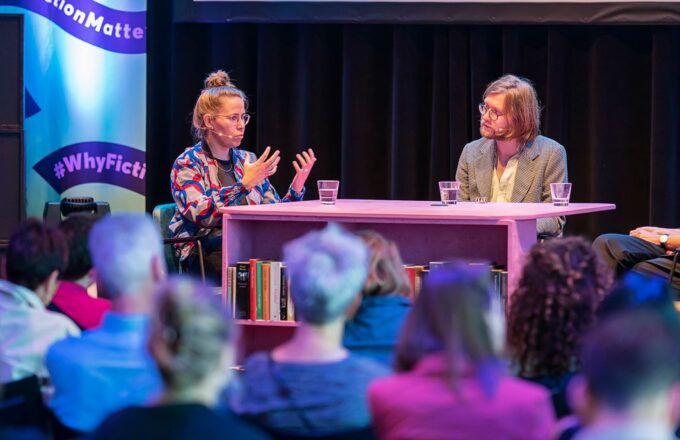 Group of people engaged in discussion at a literary salon